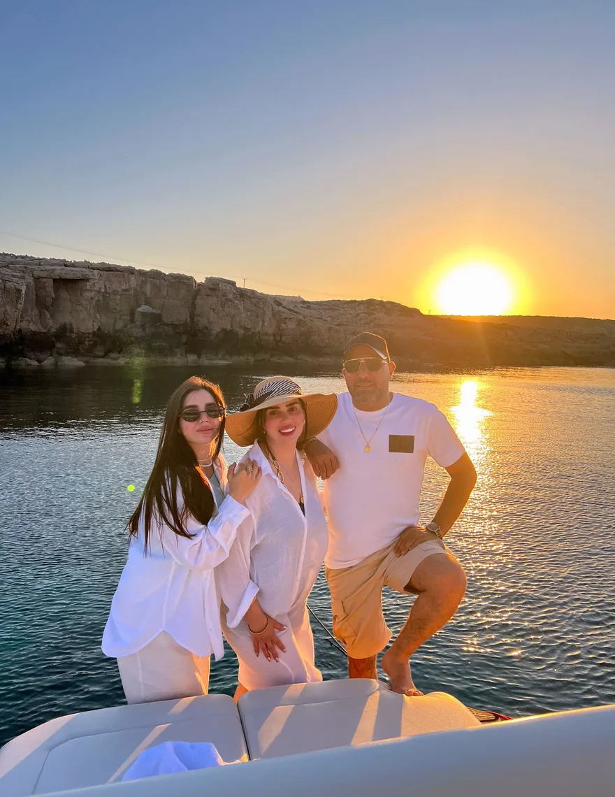 Friends celebrating at sunset on the bow of a private yacht in Cyprus