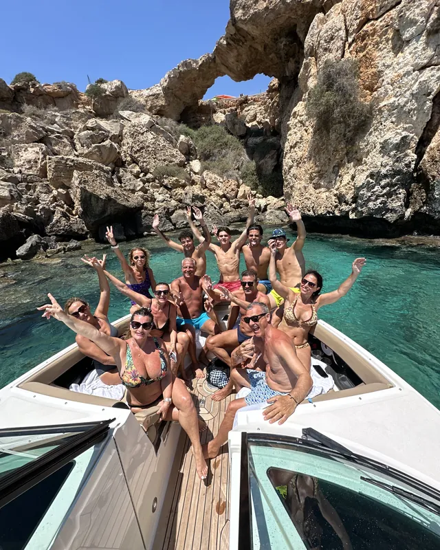 A big group cheering on the bow in a turquoise cove