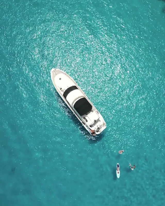 A private yacht at anchor in turquoise water, seen from above