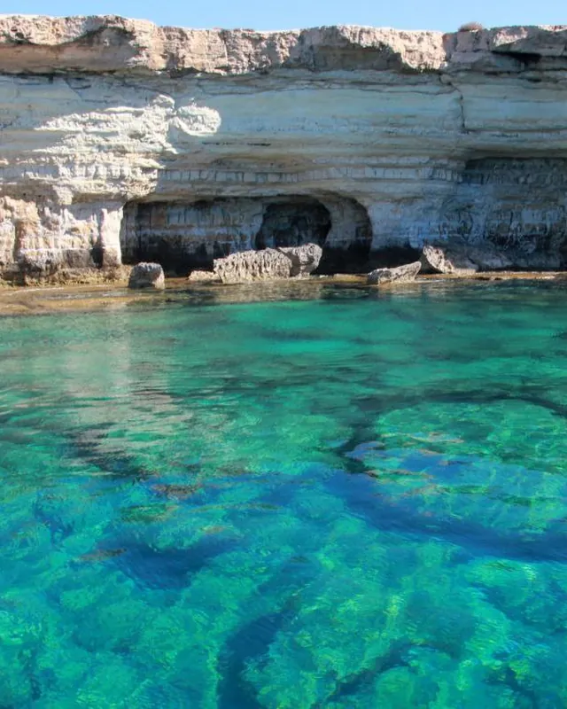 Die Meereshöhlen am Kap Greco, türkisfarbenes Wasser unter den Klippen